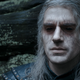 Henry Cavill as Geralt of Rivia in The Witcher, with his trademark white hair and eyes blackened after ingesting an ability-enhancing potion.